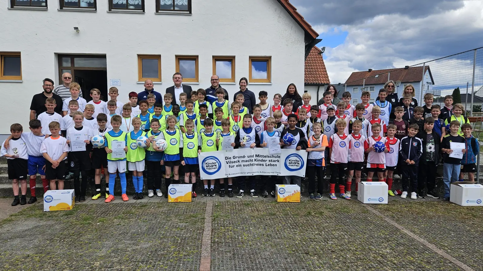 Die sechs Jungen-Mannschaften nach der Grundschul-Landkreismeisterschaft auf dem Sportgelände des FV Vilseck (von links): 1. Jahn, 2. Vilseck, 3. Hahnbach, 4. Pestalozzi, 5. Auerbach und 6. Poppenricht mit (hinten, von links) Lehrer Stefan Kroher, Karl Heinz Grollmisch, Alexander Rittner (Betreuer Vilseck), 1. Bürgermeister Hans-Martin Schertl, Martin Winkler (Betreuer Vilseck), Lehrerin Kerstin Arnold (Hahnbach). Konrektorin Daniela Schön (Pestalozzi), Studienrätin Maria Danninger (Auerbach), Rektorin Janina Schmidt und Susanne Engelhardt (beide Poppenricht). (Bild: Karl Heinz Grollmisch)