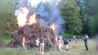 Unter Aufsicht durften die Kinder das Johannisfeuer mit Fackeln entzünden. (Bild: Kurt Scharf)