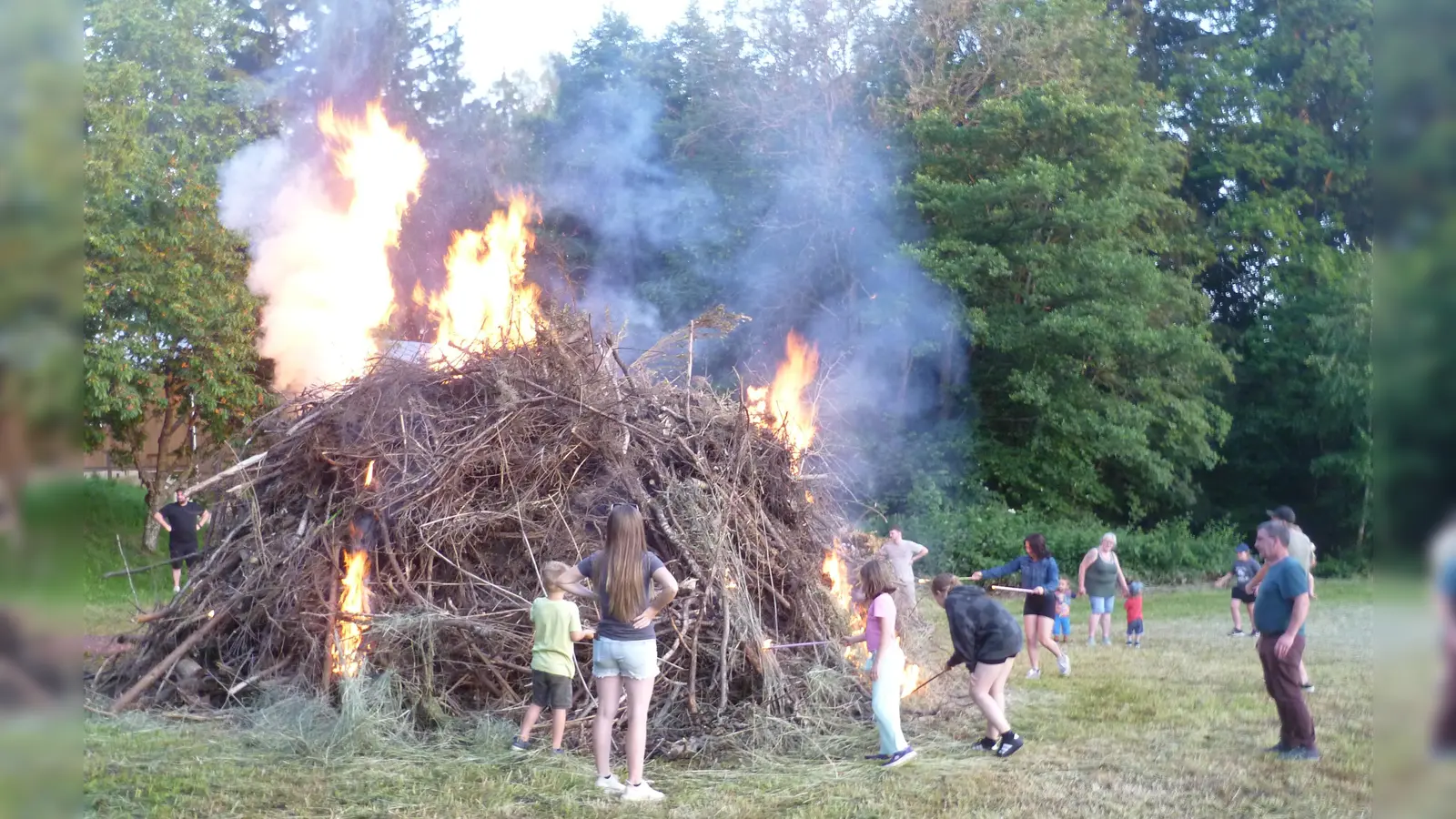 Unter Aufsicht durften die Kinder das Johannisfeuer mit Fackeln entzünden. (Bild: Kurt Scharf)