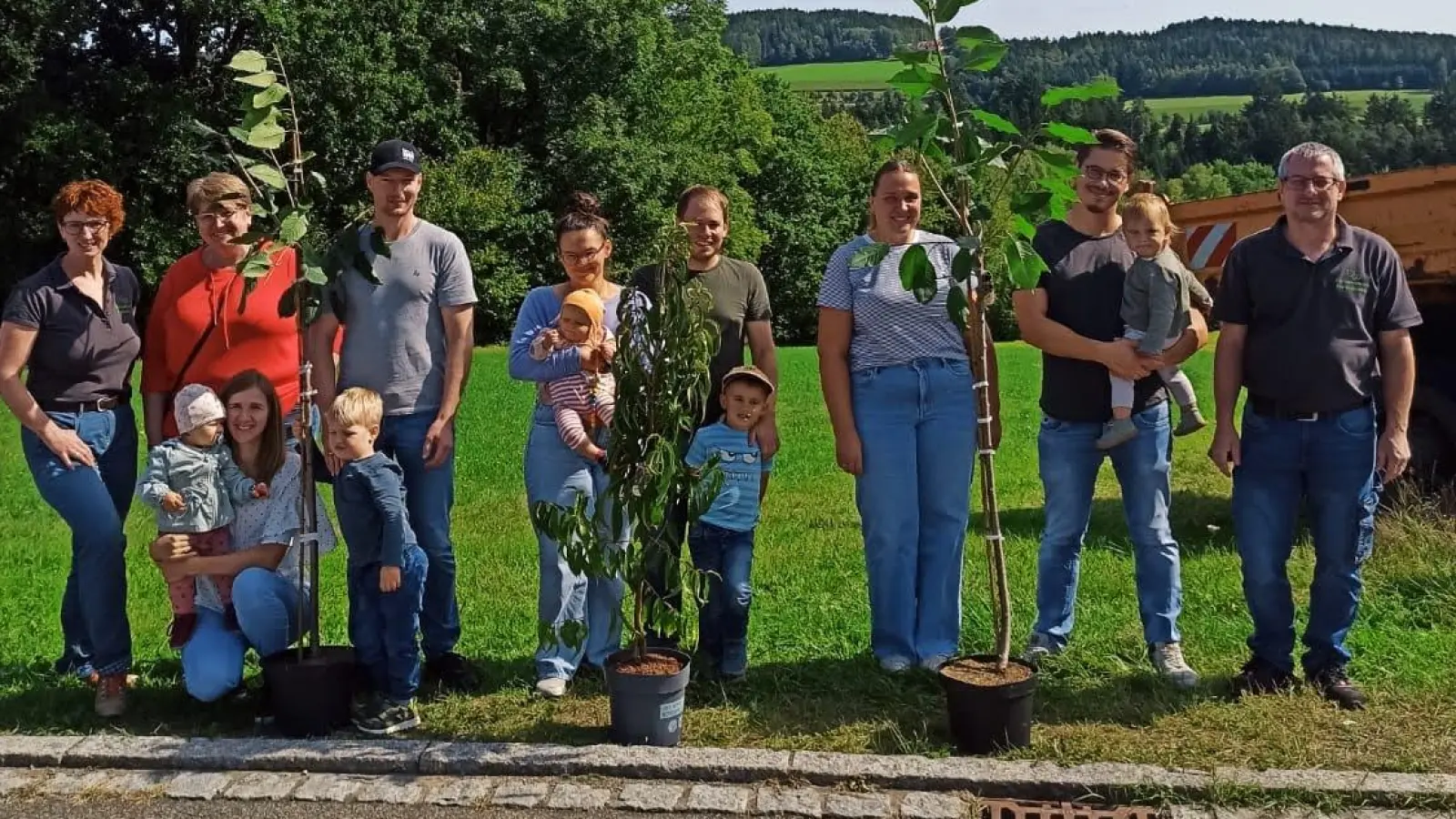 Die beiden Vorsitzenden des Gartenbauvereins Dieter Berger (rechts) und Jasmin Gassner (links) übergeben die gespendeten Babybäume an die Familien der Neugeborenen.  (Bild: Jasmin Brandl )