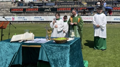 Zum Gottesdienst beim Pfarrfest suchten die Gläubigen bei hochsommerlichen Temperaturen die schattigen Plätze um das Sportheim. Einige ganz harte hielten sich auf der Tribüne auf und sorgten mit Regenschirmen selbst für Schatten.  (Bild: Theresa Schöpf )