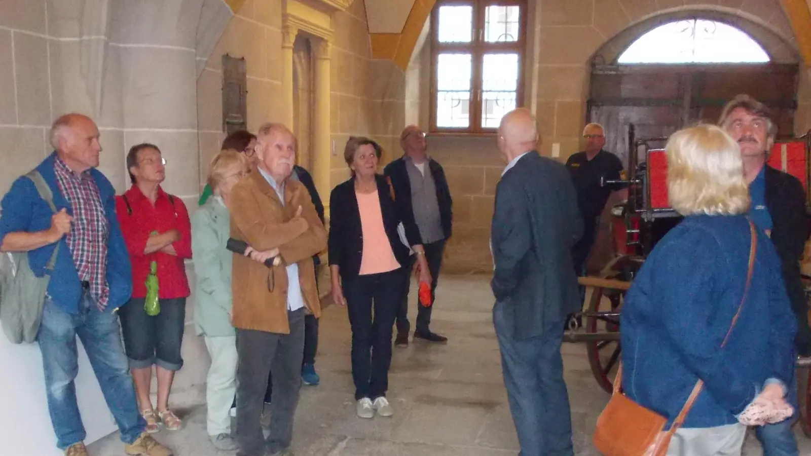 Der ehemalige Landgerichtspräsident Dr. Wolfgang Schmalzbauer (Bildmitte) lenkt die Blicke der AWA-Besucher auf das imposante Netzgewölbe der Torhalle  (Bild: Manfred Lehner)