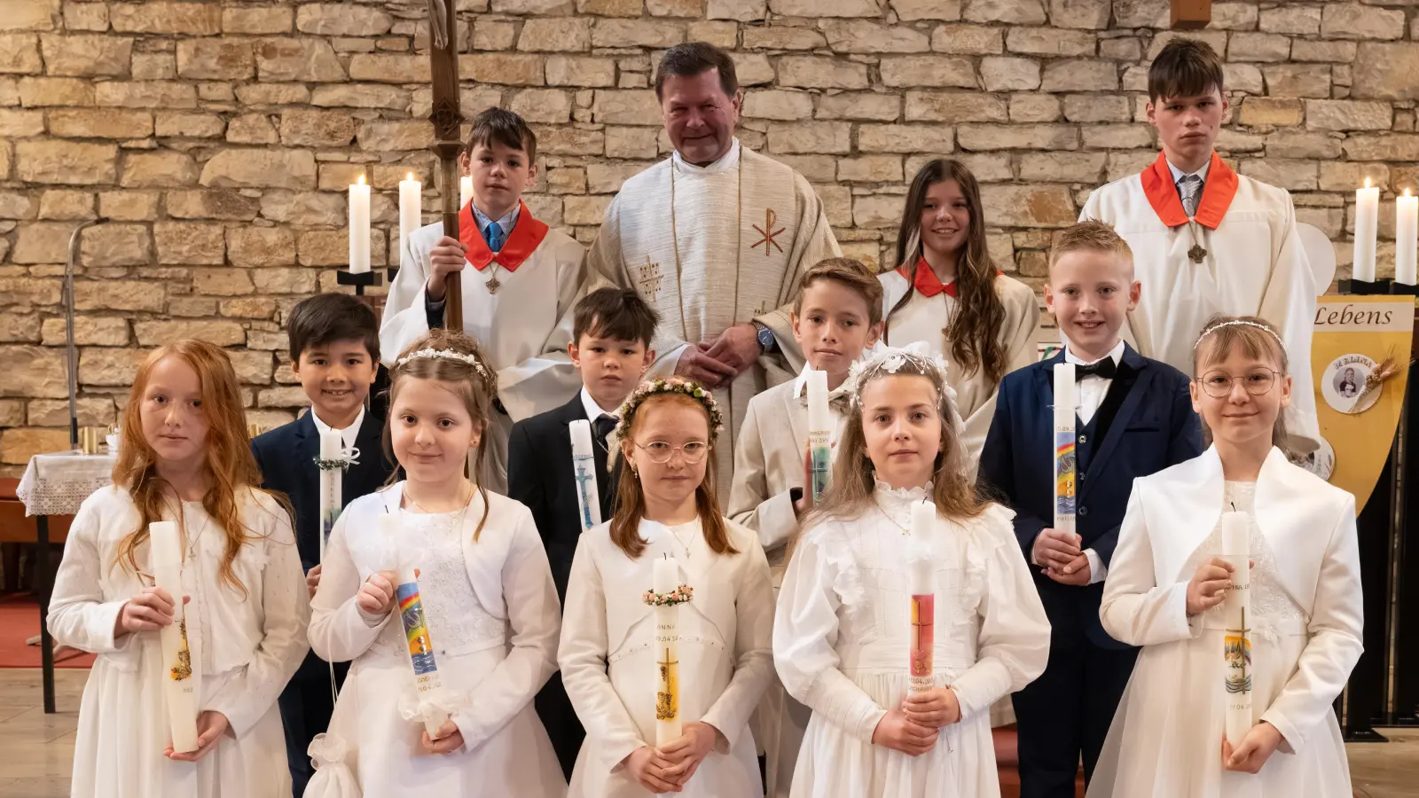 Pfarrer Hans Zeltsperger mit den Ministranten und den Erstkommunionkindern. (Bild: Uwe Guttenberger)