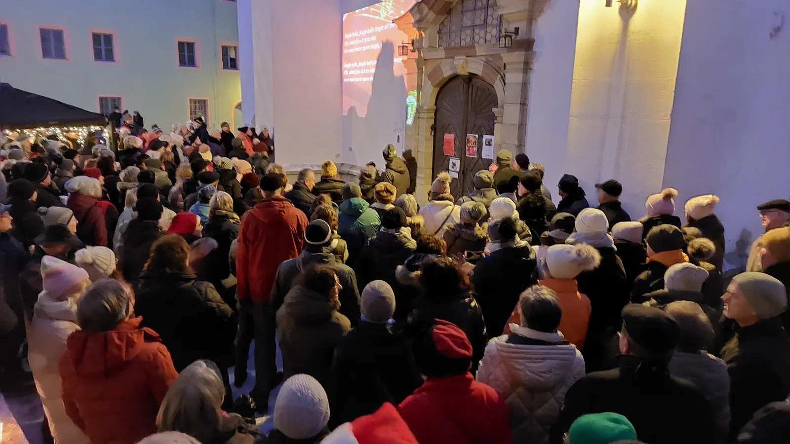 Dicht gedrängt standen die Mitwirkenden des Passanten-Chors vor dem Portal der Michaelskirche und sangen Weihnachtslieder.  (Bild: Kunz)