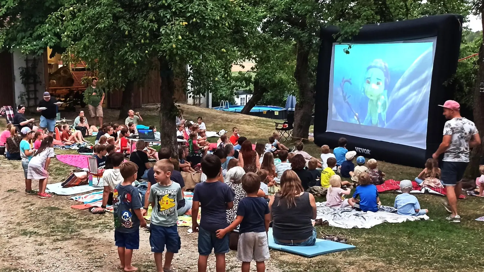 Bei Einbruch der Dunkelheit platzierten sich die Kinder und ihre Begleitung, um die große Leinwand im Wirtsgarten der Familie Michl, um den Film „Luca” anzusehen. (Bild: Norbert Weis)