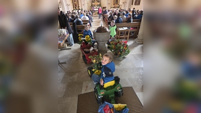 Die Kindergartenkinder ziehen mit geschmückten Tretbulldogs in die Kirche ein (Bild: Carola Helm)