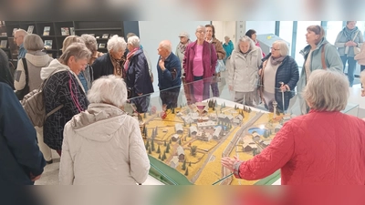 Besuch im Deutsch‑Deutschen Museum Mödlareuth: In der Eingangshalle betrachten die Teilnehmenden ein großes Modell des geteilten Ortes Mödlareuth, in dessen Mitte die ehemalige Grenzmauer sichtbar verläuft. (Bild: Johann Völkl)