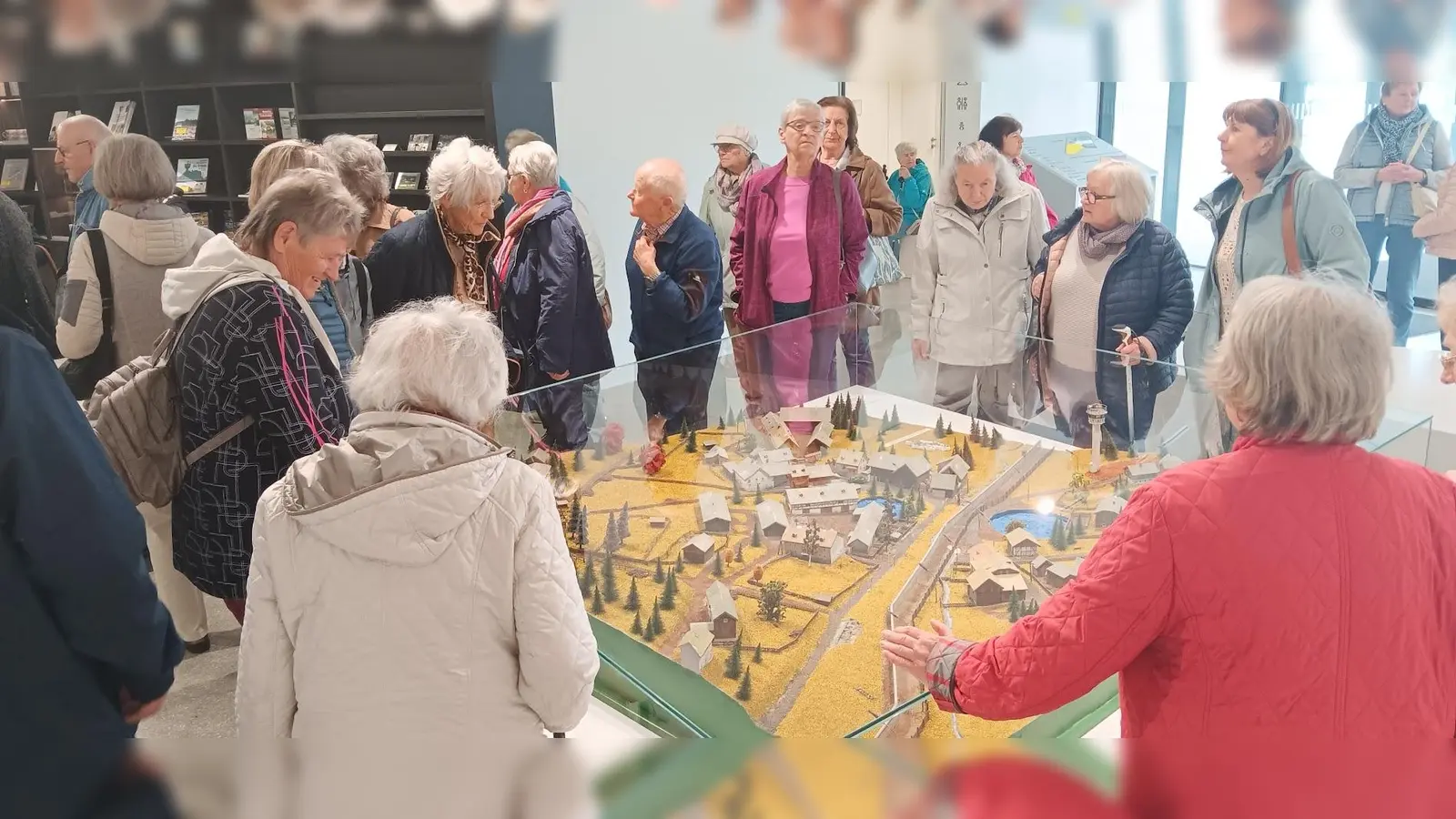 Besuch im Deutsch‑Deutschen Museum Mödlareuth: In der Eingangshalle betrachten die Teilnehmenden ein großes Modell des geteilten Ortes Mödlareuth, in dessen Mitte die ehemalige Grenzmauer sichtbar verläuft. (Bild: Johann Völkl)