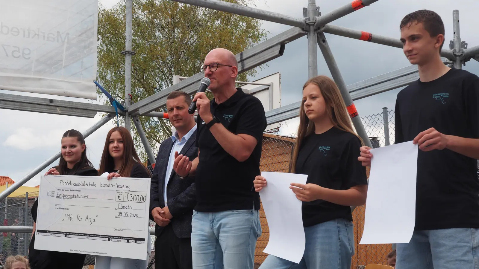 Am Ende des Festes übergaben Schulleiter Alexander Köstler (3. v.r.) und Bürgermeister Johannes Prechtl (3. v.l.) zusammen mit Schülern einen Spendenscheck an den Verein „Hilfe für Anja!“ (Bild: Sebastian Stejskal)