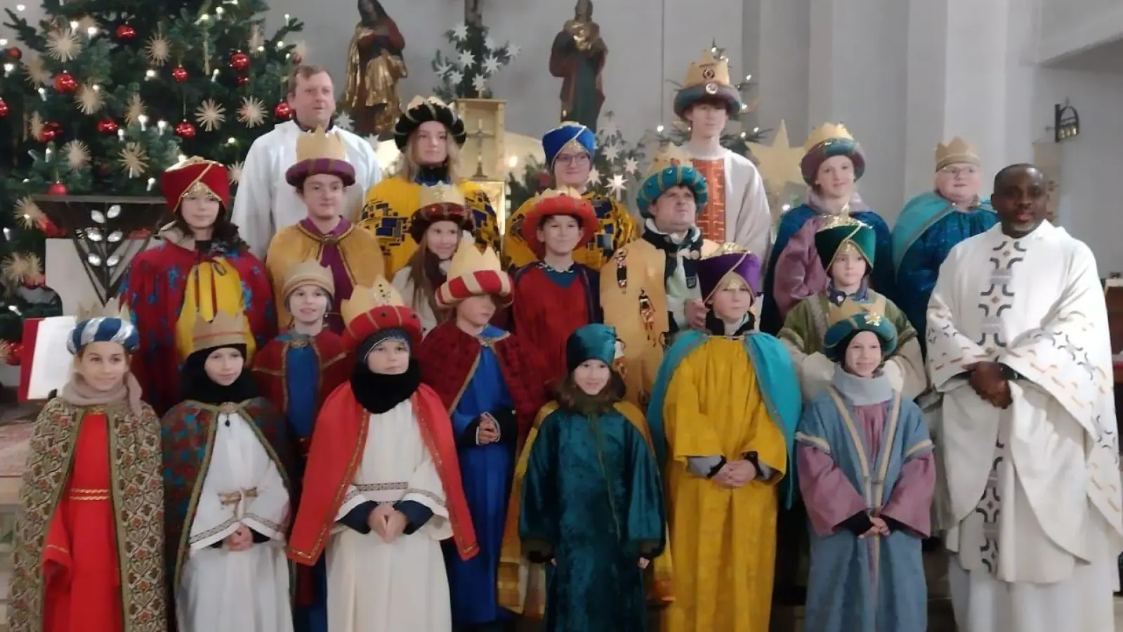Die Schar der Schwarzenfelder Sternsinger mit Pfarrvikar Christian Ogu (rechts) und Gemeindereferent Markus Seefeld (hinten links) nach der Aussendung. (Bild: Seefeld)