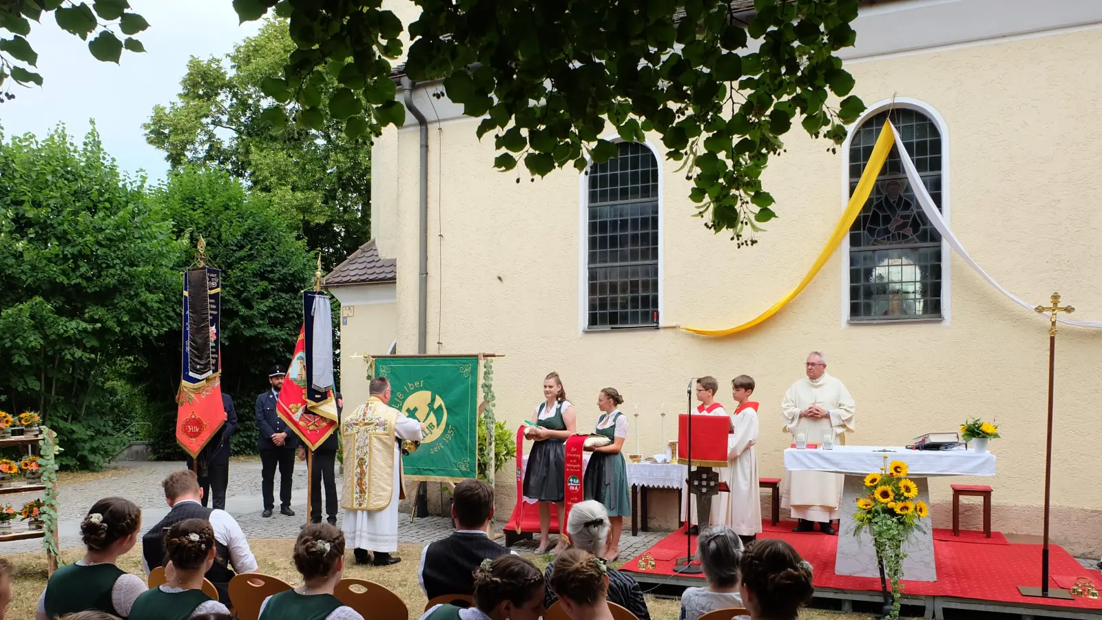 Pfarrer Michael Birner(li.) bei der Segnung der neuen Fahne mit den Fahnenbräuten, rechts Diakon Dieter Gerstacker (Bild: Markus Hubmann)