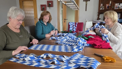 Es beginnt die eigentliche Feinarbeit, die seit Jahren in bewährten Händen liegt. Margret Eckert, Franziska Ertl und Rita Dineiger (von links) nahmen sich der Aufgabe an. In stundenlanger Handarbeit wurden Stoffe zugeschnitten, Nähte gesetzt und neue Bänder vorbereitet. (Bild: Peter Ertl)