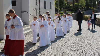 Begleitet von strahlendem Sonnenschein marschierten die Erstkommunionkinder mit Pfarrer Albert Hölzl in die Pfarrkirche St. Vitus ein. (Bild: Nikolaus Scherr)