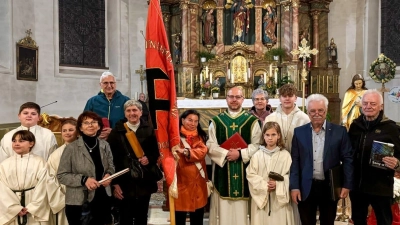 Nach dem Gottesdienst wurden von Mitgliedern die symbolhaften Gegenstände der Gabenprozession präsentiert, zusammen mit Pfarrer Norbert Förster, Sieglinde Herzing mit der Fahne sowie den Ministranten. (Bild: Klaus Eckert)