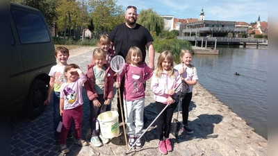 Fischwirt Christoph Kick mit den Kindern beim Fischbesatz im Fischhofpark (Bild: Erika Rahm)