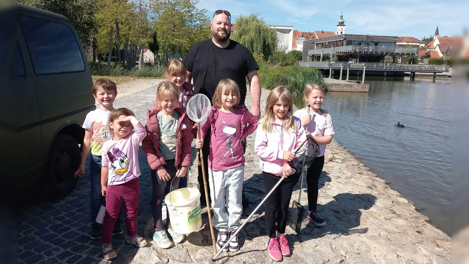 Fischwirt Christoph Kick mit den Kindern beim Fischbesatz im Fischhofpark (Bild: Erika Rahm)