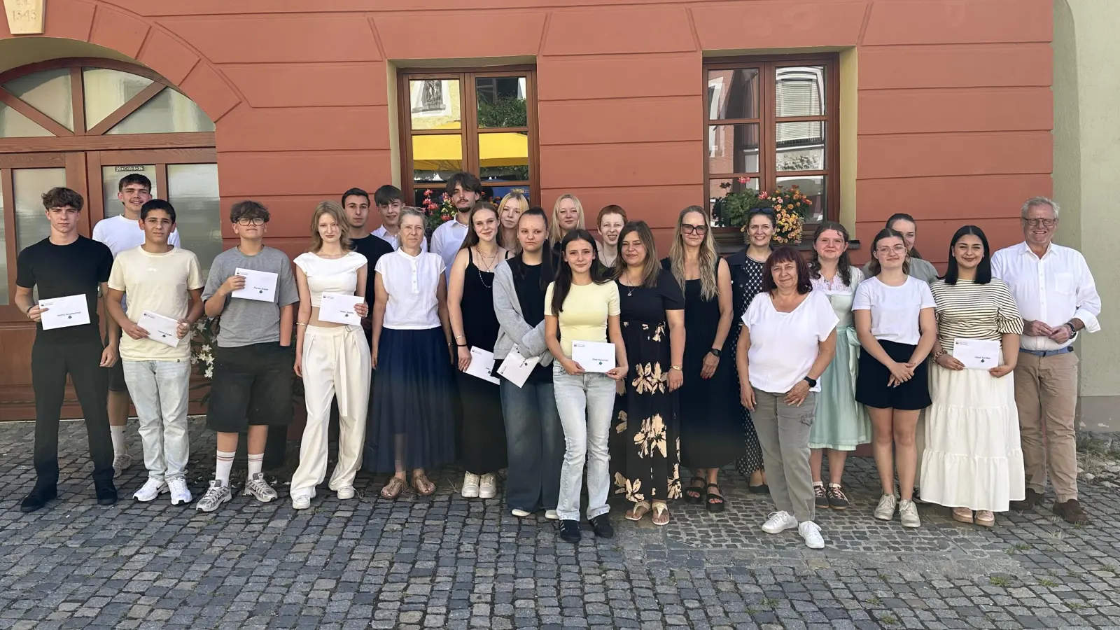 Hervorragende Ergebnisse: Insgesamt 18 Schülerinnen und Schüler der Mittelschulen Kreuzberg und Dachelhofen zeichneten Oberbürgermeister Andreas Feller (rechts) und Sabine Brunner (Stadt Schwandorf, Sachbearbeiterin Zentrale Steuerung und Dienste, 6. von rechts) aus. (Foto: Lara Schmaus)
