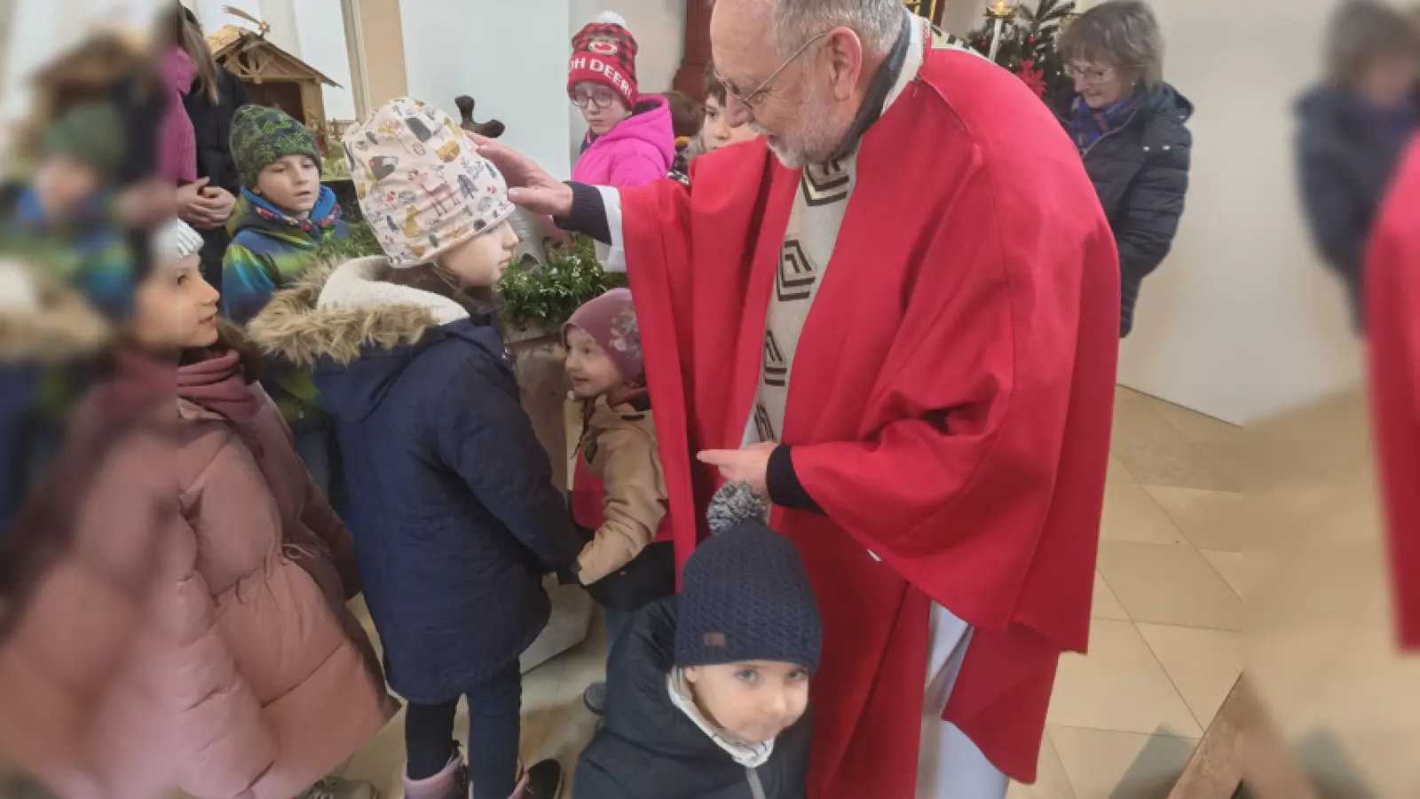 Pfarrer Alfons Forster erteilte jedem Kind einzeln den Segen vor der Krippe. (Bild: Katrin Baier)