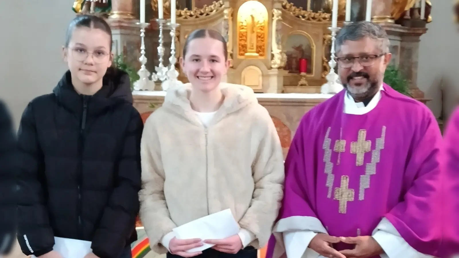 Auf eigenen Wunsch wurden in der Pfarrkirche in Michldorf Ministranten für langjährige, treue Dienste am Altar verabschiedet. Unsere Aufnahme zeigt Pfarrer Jo Jovilla Kurian mit den verabschiedeten Messdienerinnen Marie Rothballer und Stella Wiglenda. (Bild: Albert Gruber)