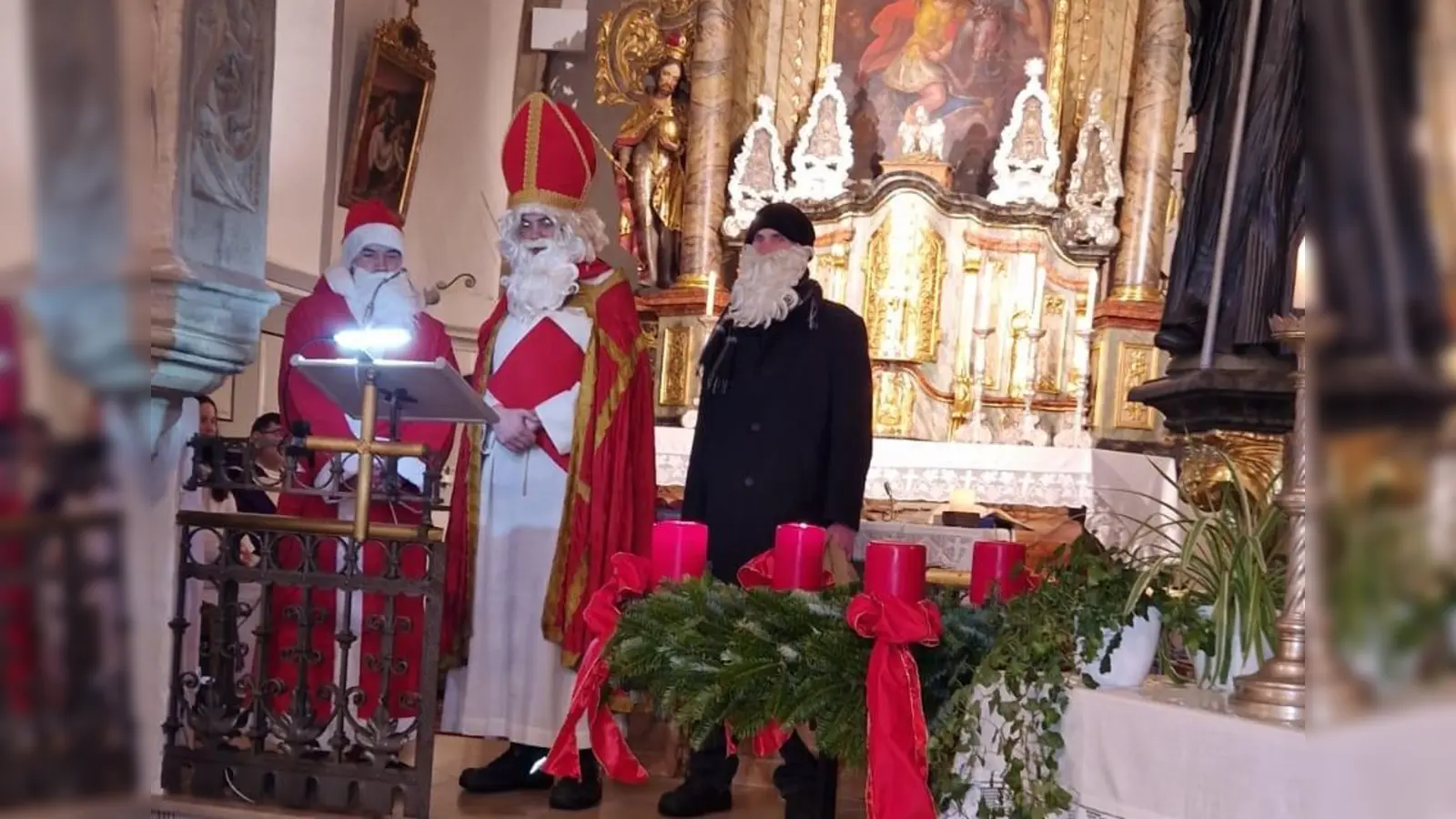 Weihnachtsmann alias Jannik Lehner, der hl. Nikolaus (Maximilian Gradl) mit Knecht Ruprecht (Luca Schindler) beim Besuch in der Kirche (Bild: Nicole Schusser-Schindler)