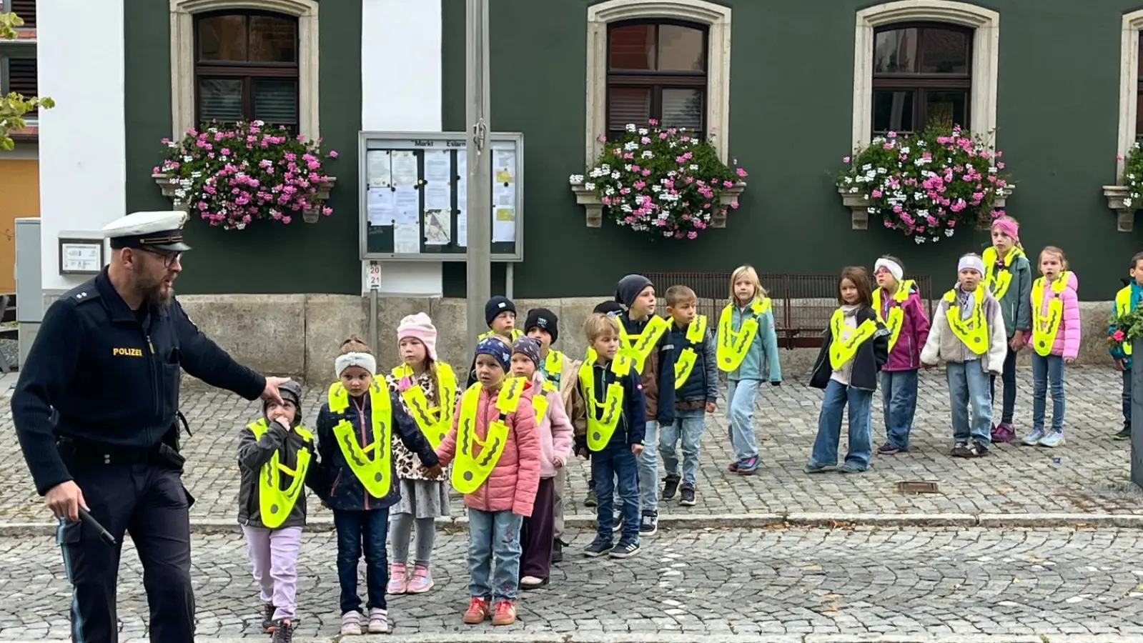 Verkehrsexperte Wolfgang Piehler lernt den Kindern „Links-Rechts-Links“, dann bis zur Straßenmitte gehen und erneut nach rechts zu schauen. (Bild: Karl Ziegler)