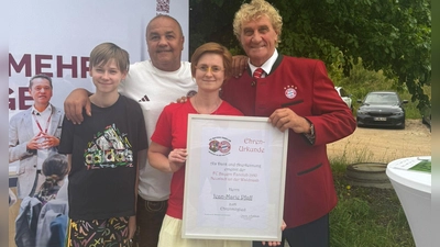 Die Vorsitzende des FC Bayern Fanclubs Neustadt/WN, Carolin Washausen, hat Jean-Marie Pfaff (ganz rechts) eine Urkunde überreicht. Mit dieser wurde der 71-Jährige zum Ehrenmitglied des Fanclubs ernannt. (Bild: Johannes Schell )