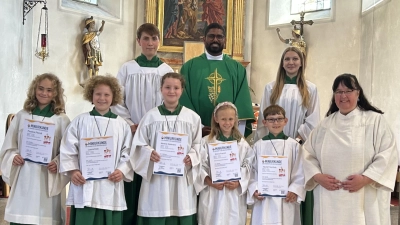 Gemeindereferentin Kerstin Wallmeyer und Pfarrvikar Dr. John Palathinkal freuen sich zusammen mit den Oberministranten Patrick Völkl und Marie Müller, fünf neue Minis begrüßen zu dürfen (Bild: Sonja Sczech)