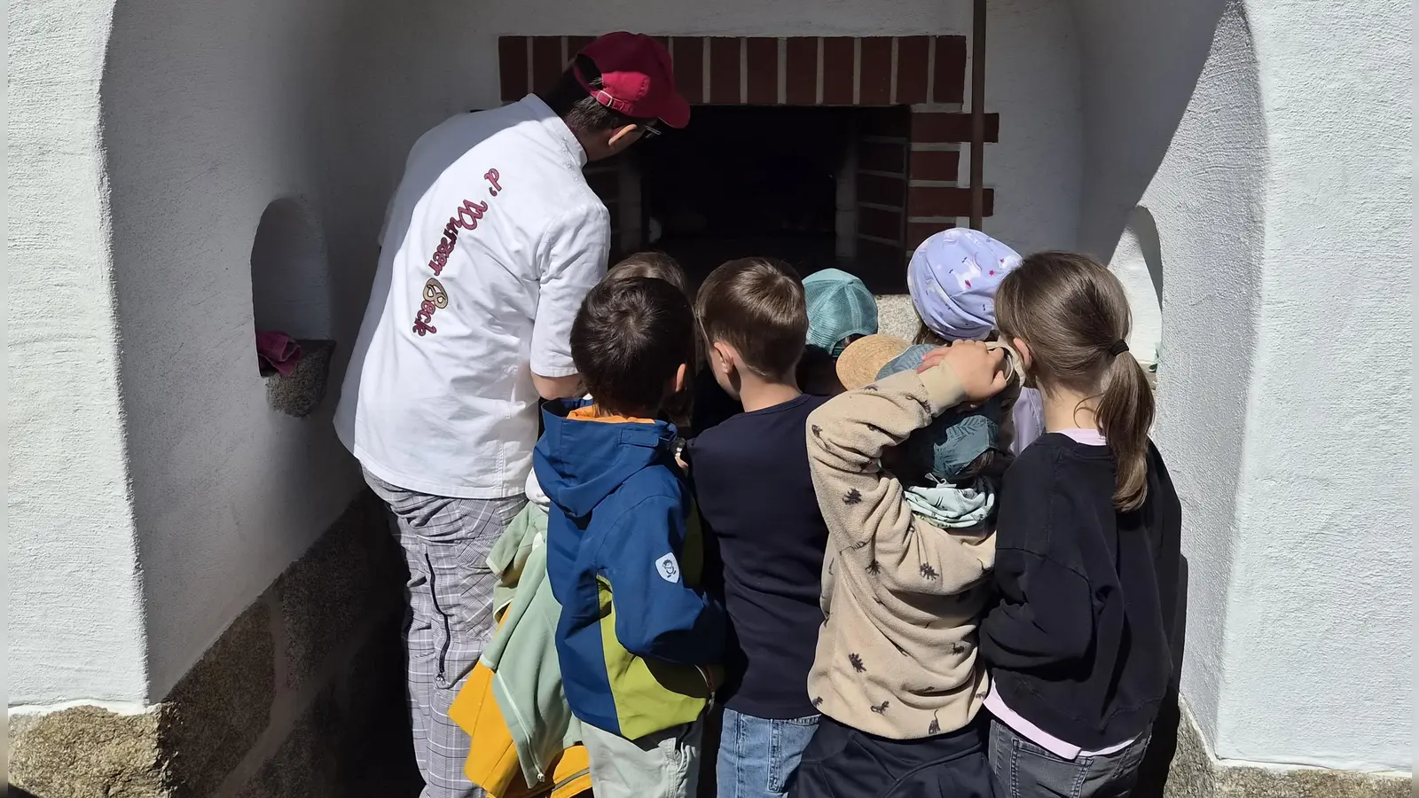 Andi Hauer mit den Kindern am Backofen. (Bild: Melanie Windschiegl)