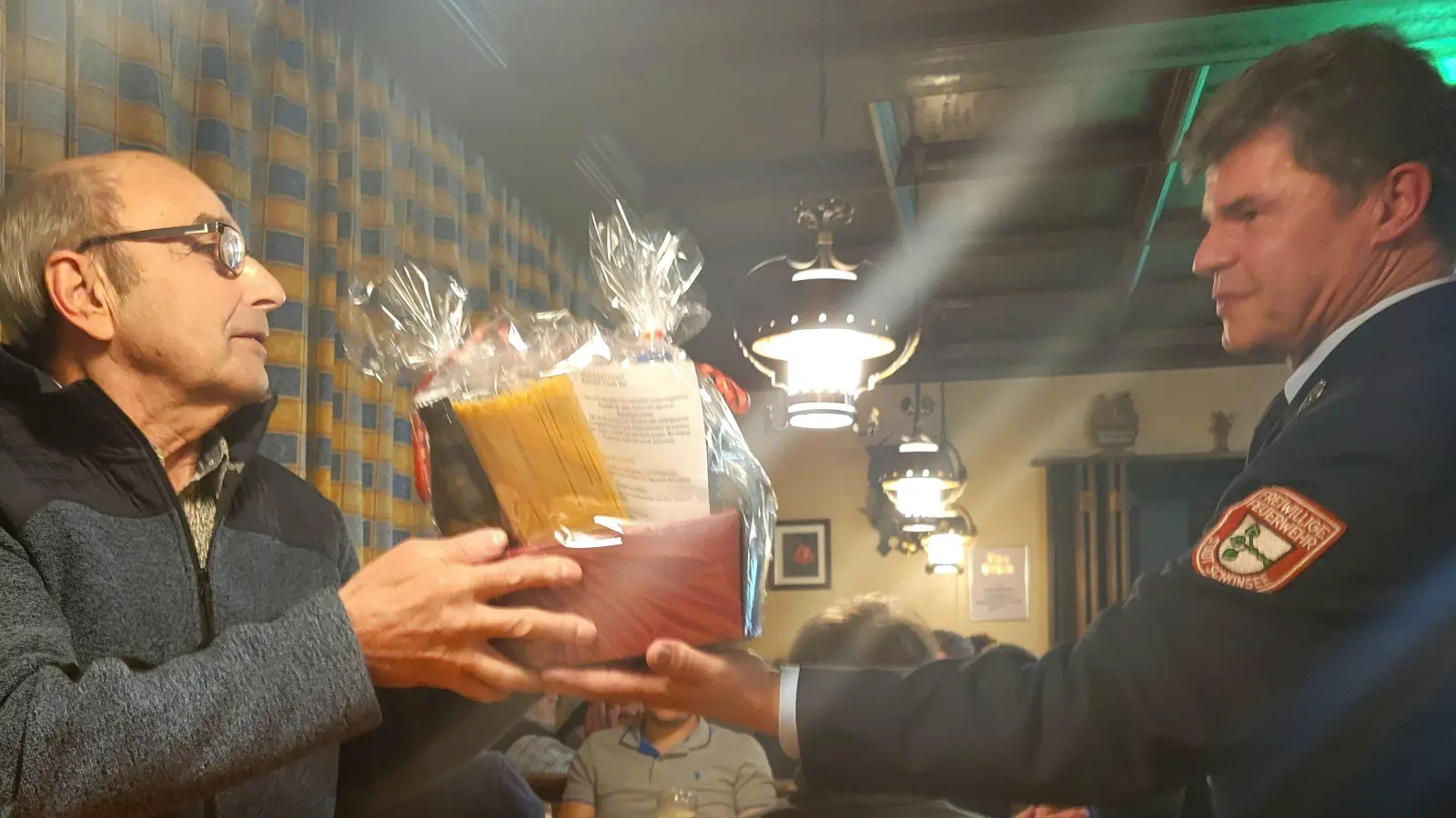 Siegfried Hammerer (links) erhält vom Vorsitzenden der Feuerwehr, Xaver Bayer, ein Abschieds-Präsent.  (Bild: Feuerwehr Schönsee/exb)