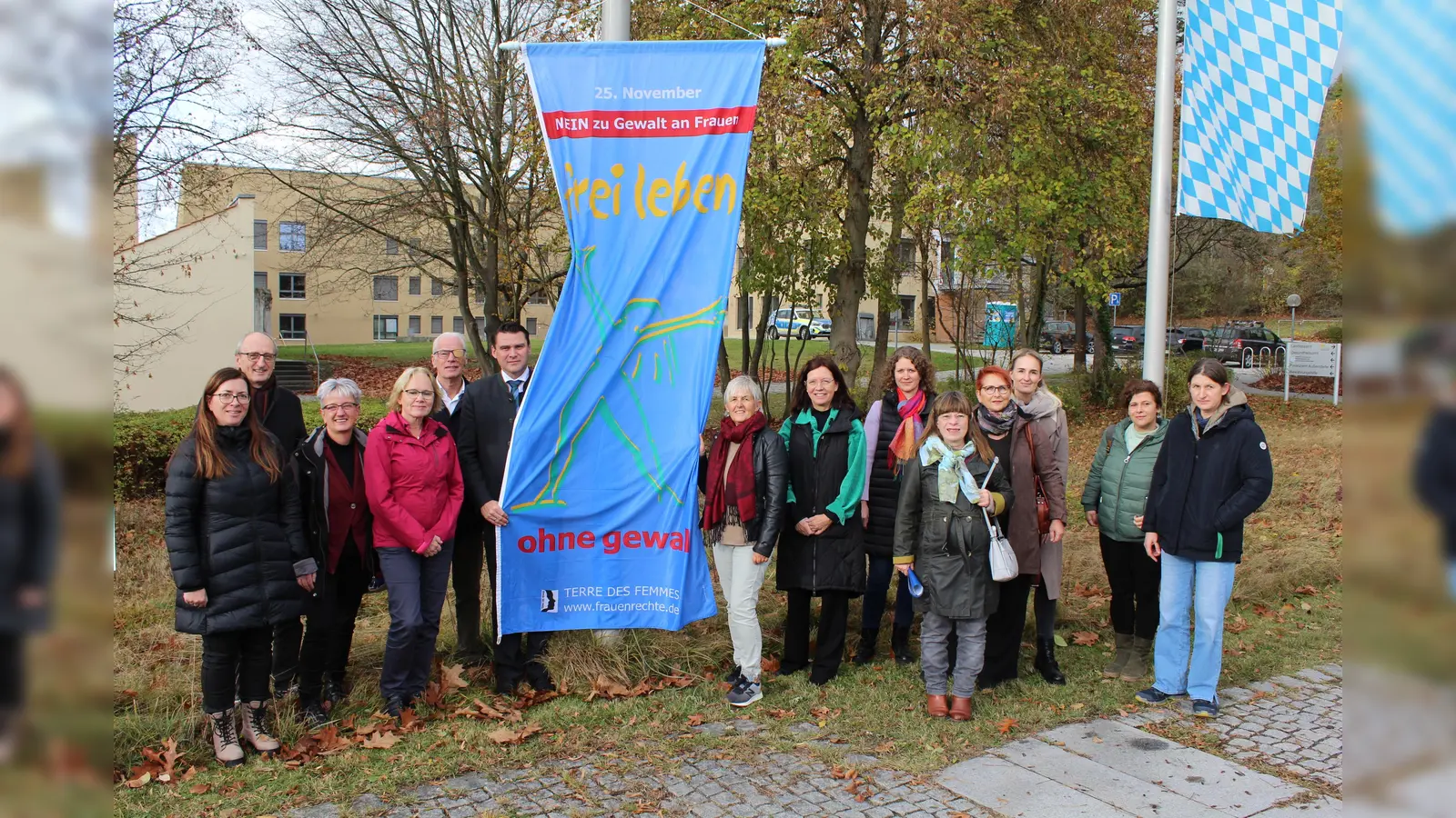 Landrat Thomas Ebeling und Kooperationsbeteiligte hissen am Landratsamt die Flagge zum Gedenktag „Nein zu Gewalt an Frauen“.<br> (Bild: Prechtl/LAA Schwandorf/exb)