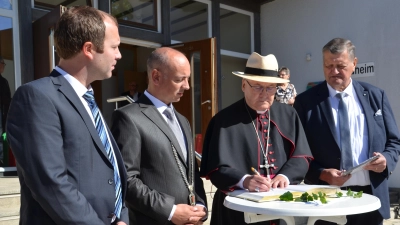 Im Beisein der Bürgermeister Tobias Dirrigl und Florian Adam (von links) sowie Franz Ziegelmeier (ganz rechts) trug sich Diözesanbischof Rudolf Voderholzer nach dem Festgottesdienst in das Goldene Buch der Gemeinde Fensterbach ein. (Bild: Wolfgang Houschka)