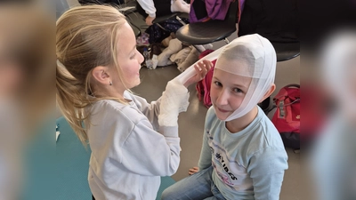 So ein Kopfverband mit Binde ist gar nicht so einfach. Doch mit etwas Übung bekommen das auch Grundschüler hin. (Bild: Nikolaus Scherr)