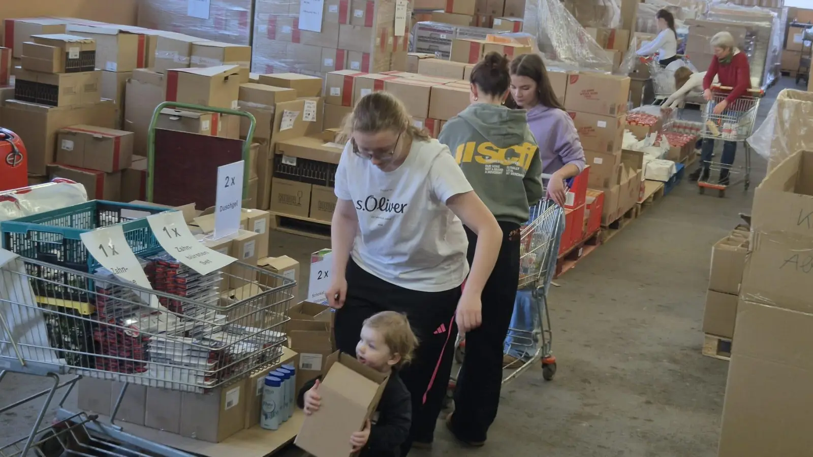 Über 300 Hilfspakete packten Mitglieder der Kolpingsfamilie, des Katholischen Frauenbunds und der Jugendgarde des Neustädter Faschingsvereins in den Räumen der Firma F.X. Nachtmann. Sie werden am 25.12.2025 mit den Johanniter-Weihnachtstruckern nach Rumänien und in die Ukraine transportiert. (Bild: Martin Steger)