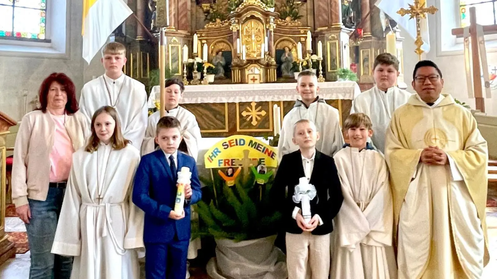 in der Mitte die beiden Erstkommunikanten, links Marion Eschenweck begleitete die Kinder bei der Feier, rechts Pater Samuel Patton, eingerahmt von den Ministranten. (Bild: Sonja Schwemmer)