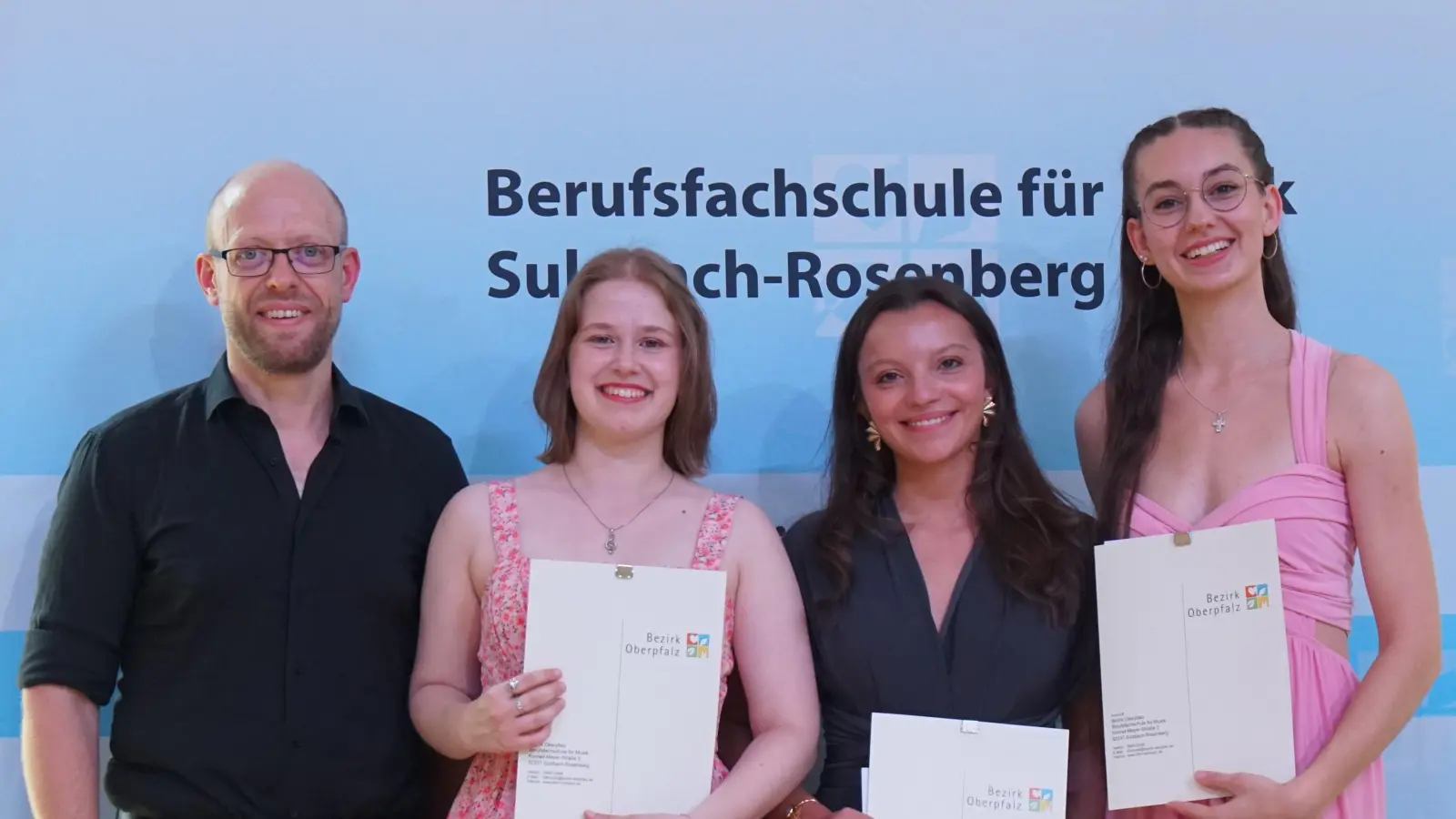 Schulleiter Dominik Lehmeier mit drei von vier der Jahrgangsbesten (von links): Emilia Bolz, Smilla Maier sowie Tabitha Badstübner. Der vierte im Bunde, Marian Metsch, musste sich für die Zeugnisvergabe leider entschuldigen. (Foto: Anna Heidenreich)