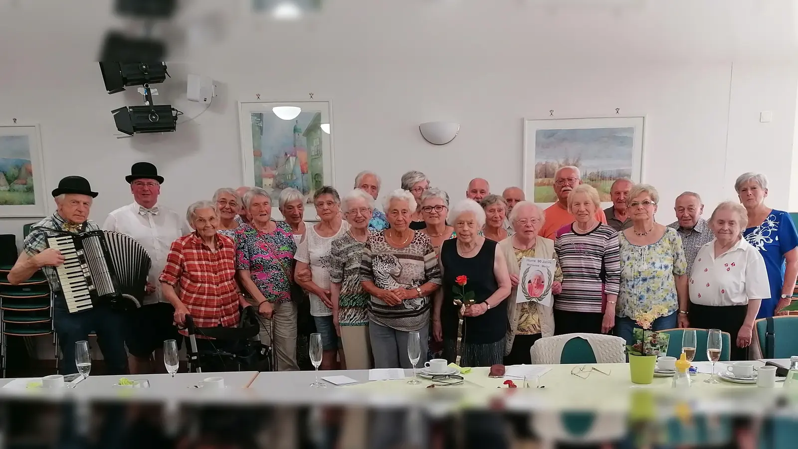 Teilnehmer des Seniorentreffs mit der Jubilarin Marianne Meiler (vorne Mitte mit Rose), Seniorentreffleiterin Elisabeth Schaller (rechts) sowie Musikant Erhard Hirmer und Kolpingvorsitzender Michael Koller als festliche Gratulanten (links). <br><br> (Bild: Michael Koller)