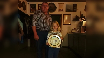 Jugenleiter Richard Meisinger übergibt die Kirchweihscheibe der Schülerklasse an die Gewinnerin Eva Linsmeider.  (Bild: Kerstin Wild)
