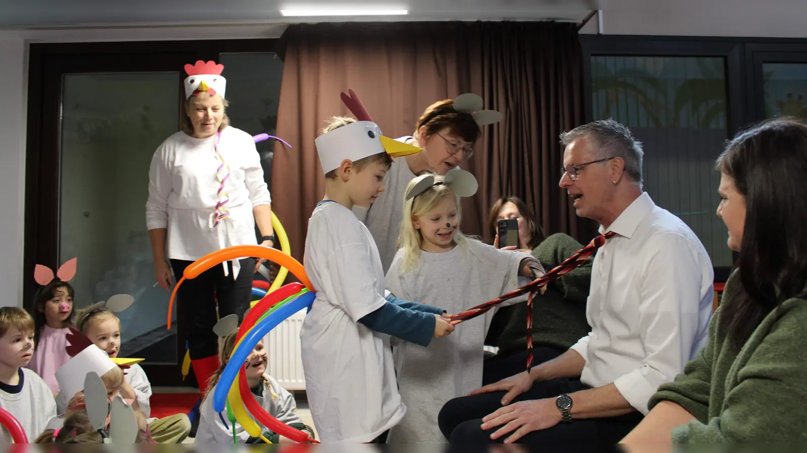 Bürgermeister Hermann Falk nahm es wie alle Jahre mit Humor – am Unsinnigen Donnerstag muss seine Krawatte dran glauben. Dafür sorgen alle Jahre die Kleinen des St. Wolfgang-Kindergartens. Heuer waren Nora und Noah die Übeltäter. (Bild: Martina Dolles)
