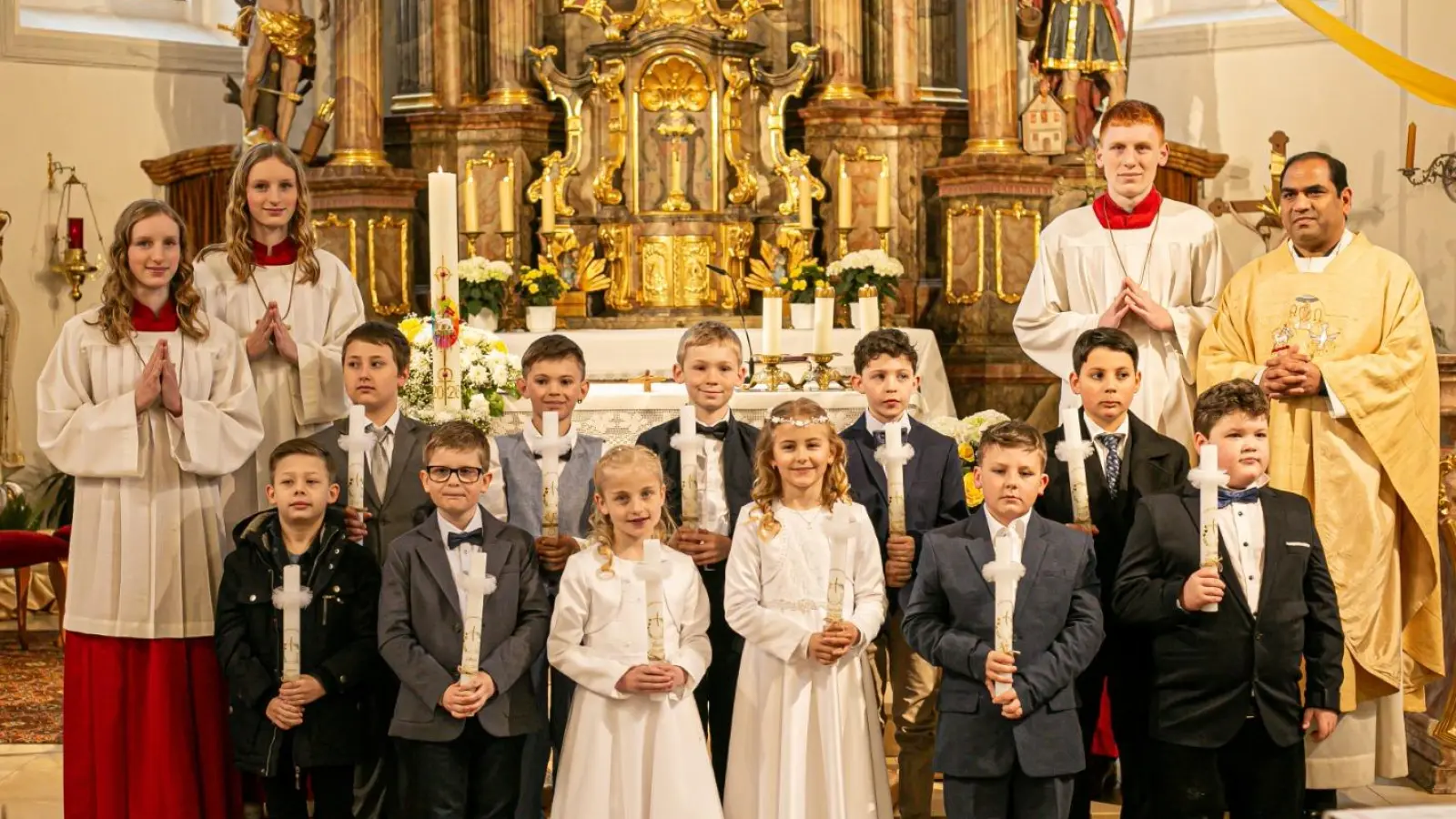 Pfarrer Benny zusammen mit den Ministranten und den Kommunionkindern vorne von links: Jonas Bohmann, Johan Schwemmer, Marie Lederer, Franziska Bauer, Jamie Mayer, Jerome Roppert 2. Reihe v. l.: Lukas Stich, Luca Greim, Felix Eglmeier, Leonhard Koppmann, Giovanni Ferrari (Bild: Jessica Caudill)