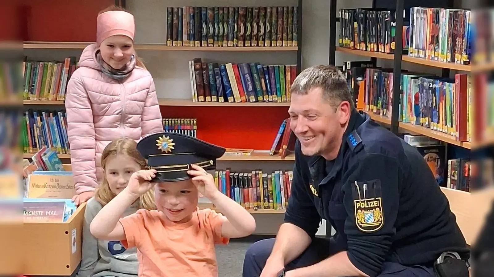 Mit sichtbarem Stolz probiert ein Kind die Polizeimütze auf. (Bild: Claudia Landgraf)