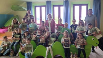 Martin Neumann vom Kreisjugendring, Ingrid Jesse und Katja Meidenbauer von der Grundschule Vohenstrauß freuen sich mit der Gewinnerklasse über ihre Preise und Bücher. (Bild: Silke Wittmann)