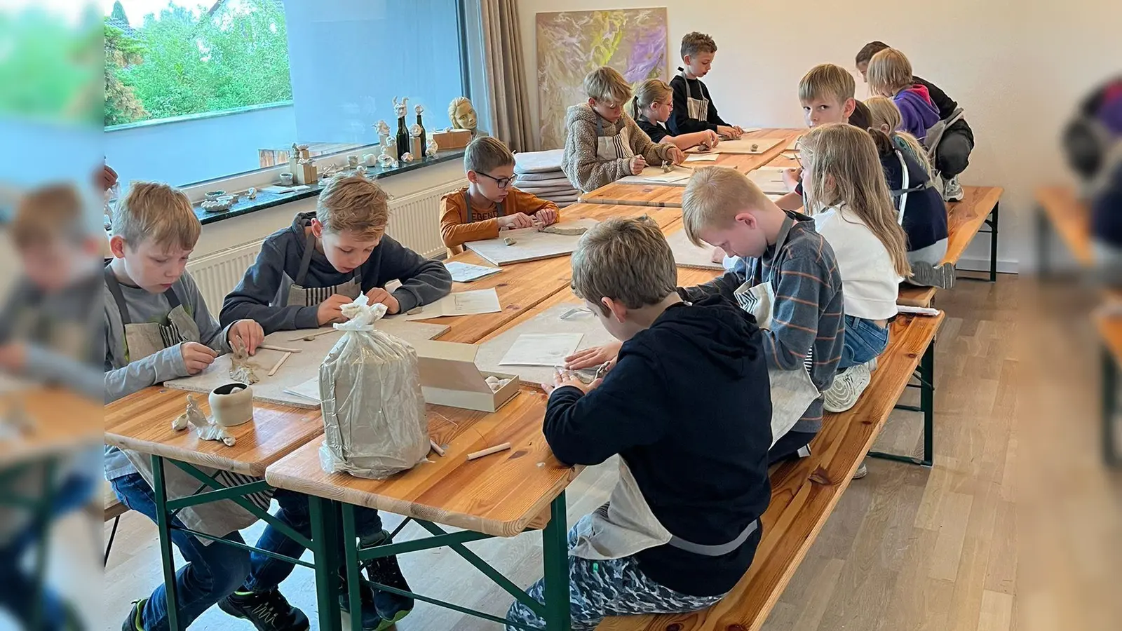 Anstatt bei schlechtem Wetter im Matsch zu spielen, untersuchen 13 Mädchen und Jungen unter Anleitung von Antje Gradl den Werkstoff Ton. (Bild: Christina Zintl )