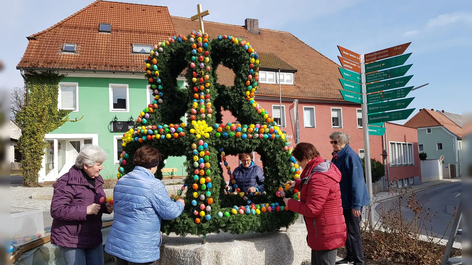 Mitglieder des Frauenbundes haben den Brunnen am Marktplatz mit einer Osterkrone geschmückt. (Bild: Peter Garreiss)