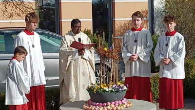 Pfarrer Celestine segnete den österlich geschmückten Quellstein in Wolfring. (Bild: Franz Ziegelmeier)