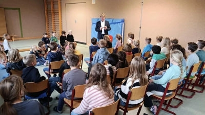 Die Vorschulkinder und Grundschüler hören gespannt dem Lesevortrag des Bürgermeisters Markus Schiesl zu. (Bild: Tanja Schlehuber)