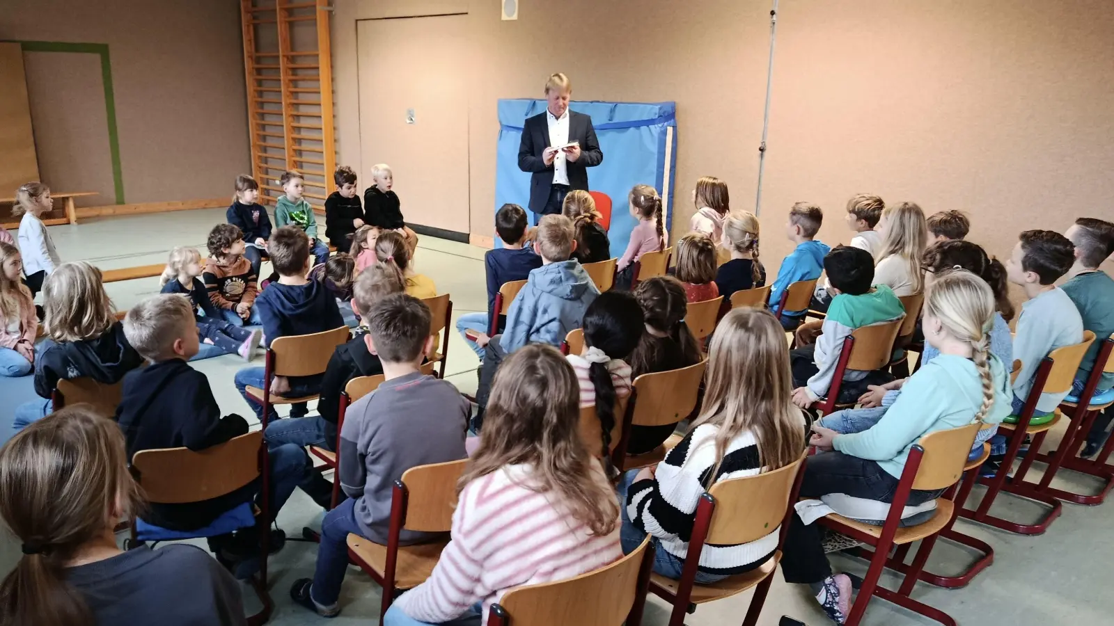 Die Vorschulkinder und Grundschüler hören gespannt dem Lesevortrag des Bürgermeisters Markus Schiesl zu. (Bild: Tanja Schlehuber)