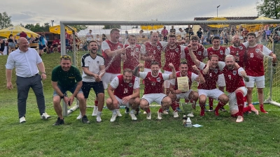 Der Sieger beim Kleinfeld-Cup 2026 in Schnaittenbach heißt „Alpen Spalter” - auf dem Foto die jubelnden Spieler zusammen mit Schirmherr 1. Bürgermeister Marcus Eichenmüller (hinten links) und Turnierleiter Günther Schatz (vorne links) (Bild: Dieter Pröm)