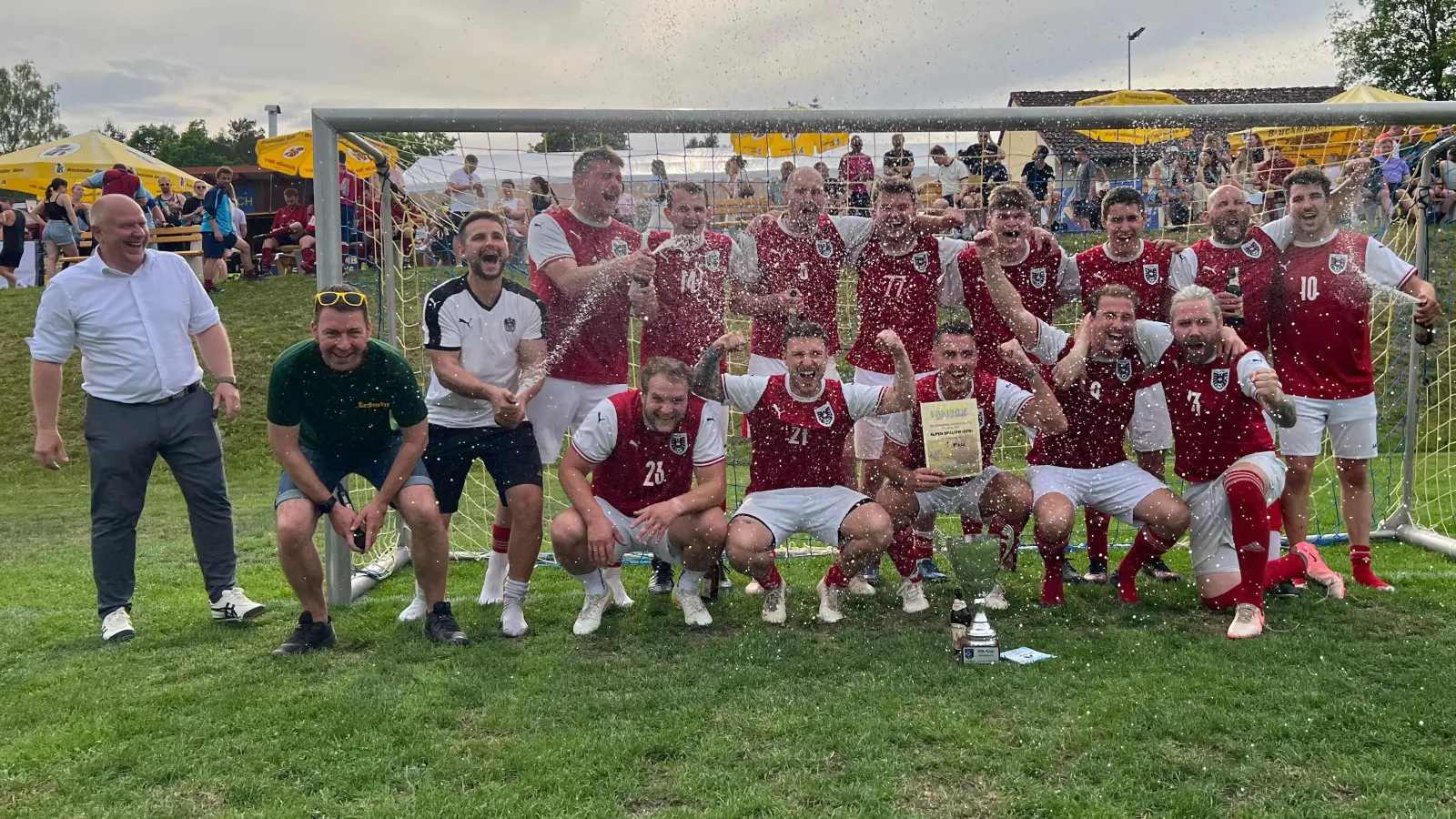 Der Sieger beim Kleinfeld-Cup 2026 in Schnaittenbach heißt „Alpen Spalter” - auf dem Foto die jubelnden Spieler zusammen mit Schirmherr 1. Bürgermeister Marcus Eichenmüller (hinten links) und Turnierleiter Günther Schatz (vorne links) (Bild: Dieter Pröm)