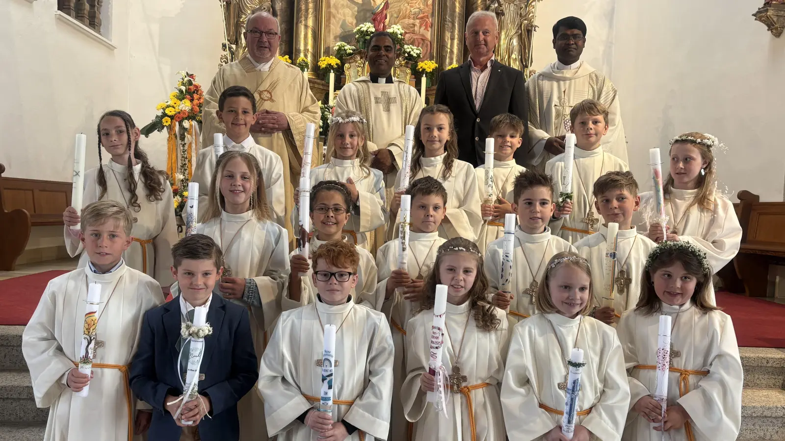 Auf dem Bild die 18 Kommunionkinder in den ersten drei Reihen, dahinter Diakon Harald Schraml, Pfarrer Julius, PGSpr. Robert Bauer und Pater Arul. (Bild: Alexander Hörl)