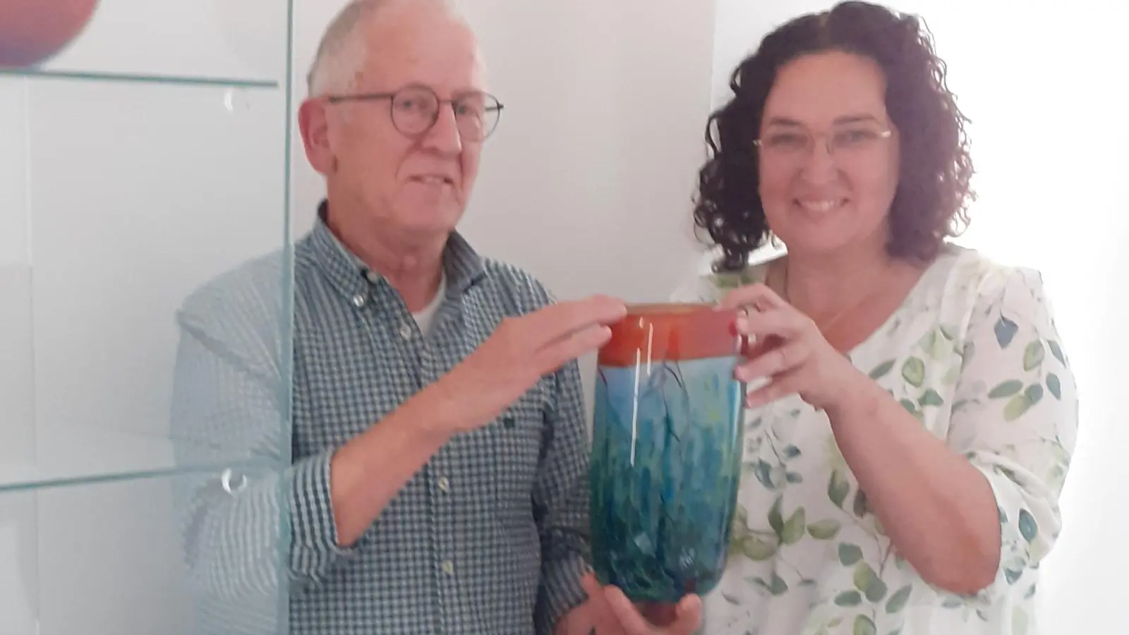 Benno Krottenthaler (links) zeigt der Ersten Bürgermeisterin Tina Zeitler das neue Ausstellungsstück, die Vase „Blumenwiese“ aus der Manufakturkollektion der Glasfachschule Ziesel. Die Vitrine steht im Flur unmittelbar vor dem Sitzungssaal im Rathaus. (Bild: Manfred Kopp)